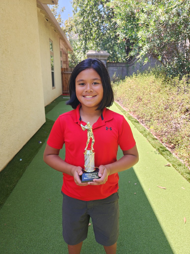 Shay holding a junior golf championship trophy